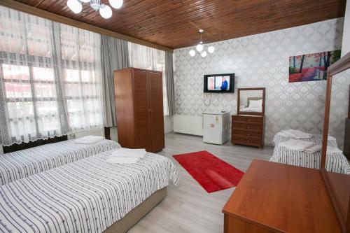 a bedroom with two beds and a table and a tv at Çarşı butik otel in Amasra