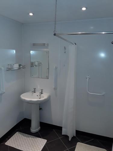 a white bathroom with a sink and a shower at Langport Arms Hotel in Langport