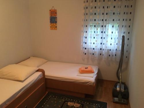 a small room with two beds and a window at Apartment Sanja in Baška Voda