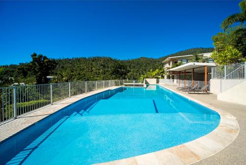 a large blue swimming pool on top of a house at Airlie Summit Apartments in Airlie Beach