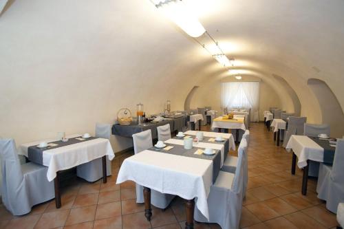 a dining room with white tables and chairs at Hotel Pinamonte in Costermano sul Garda