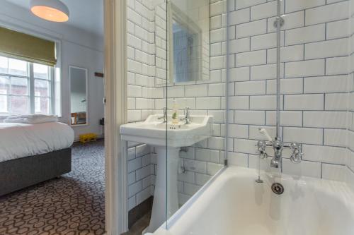 a bathroom with a sink and a bath tub at The Dolphin in Newbury