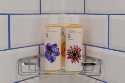 two bottles of moisturizers on a shelf in a bathroom at The Dolphin in Newbury