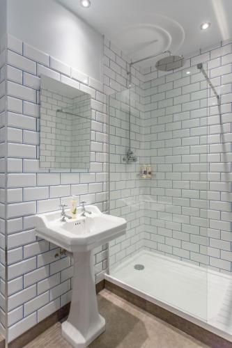 a white bathroom with a sink and a shower at The Dolphin in Newbury