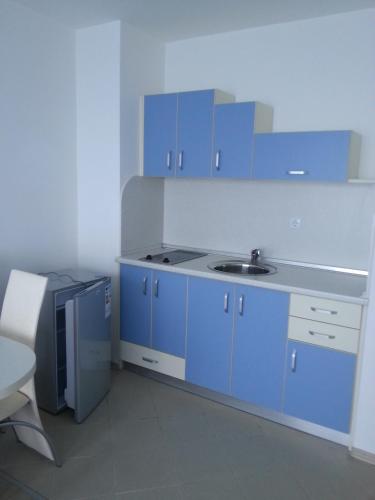 a blue kitchen with a sink and blue cabinets at Blue Bay Palace Apart Complex in Pomorie