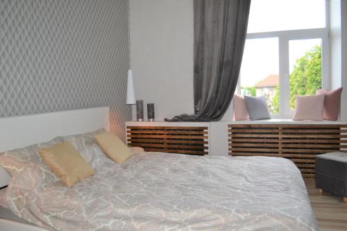 1 dormitorio con cama con almohadas y ventana en Vee 4 City Center Apartment en Pärnu