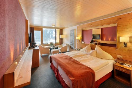 a hotel room with a large bed and a desk at Eiger Mountain & Soul Resort in Grindelwald
