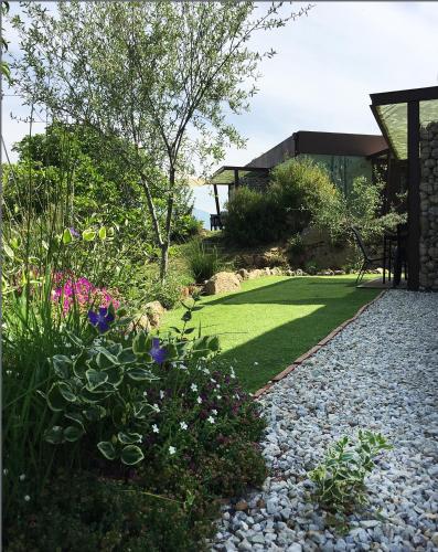 a garden with flowers and grass and a house at Veragua. Glamping y Apartamentos turísticos in Villanueva de la Vera