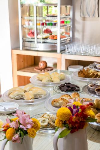 a table with plates of food and flowers on it at Pousada da Terra in Natal
