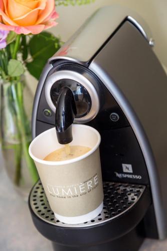 a cup of coffee in a coffee machine at Boutique Hotel Lumiere in Eindhoven