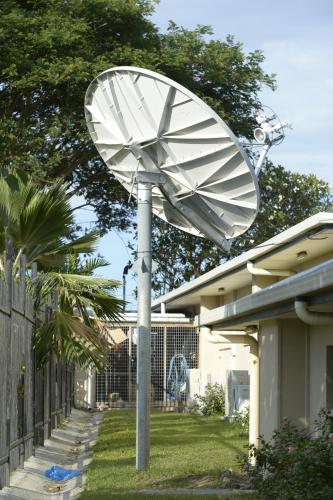 a satellite dish on a pole in front of a house at Gazelle International Hotel in Kokopo