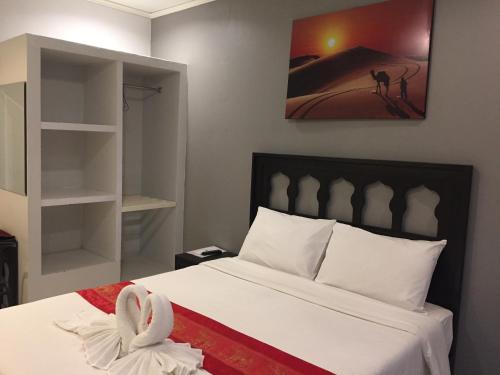 a bedroom with a bed with white sheets and a painting at PPS Home in Surin