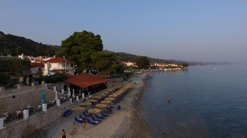 a beach with umbrellas and people on the water at Villa Maria mola in Mola Kalyva