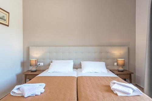 a bedroom with two beds with towels on them at Villaggio Verde in Laganas