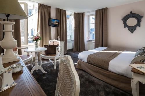 um quarto de hotel com uma cama, uma mesa e cadeiras em Hotel Arvor - O'Lodges by Arvor em Dinan