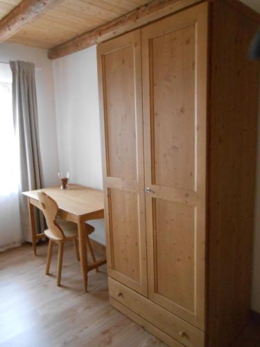 a wooden cabinet in a room with a wooden table at Agriturismo La Casa Nei Boschi in Colderù