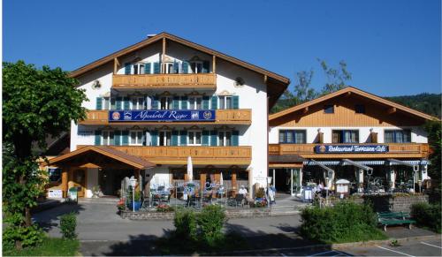 a large building with tables and chairs in front of it at Alpenhotel Rieger in Mittenwald