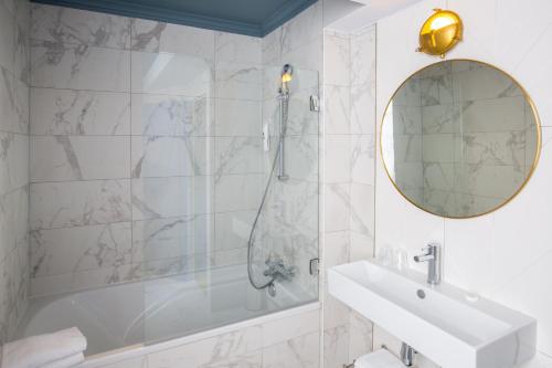 y baño con ducha, lavabo y espejo. en ibis Styles Paris Nation Cours de Vincennes en París