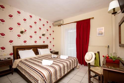 a bedroom with a bed and a red wall at Philoxenia Inn in Limenas
