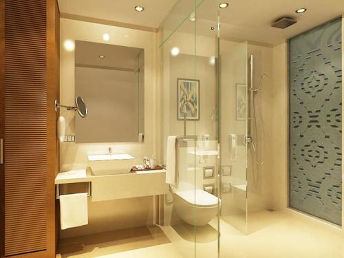 a bathroom with a toilet and a sink and a shower at The Sahil Hotel in Mumbai