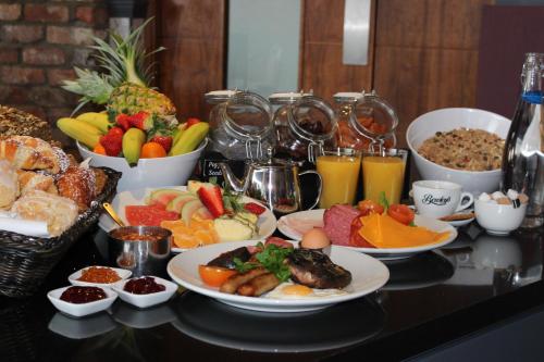 a table topped with plates of food and bowls of fruit at Absolute Hotel Limerick in Limerick