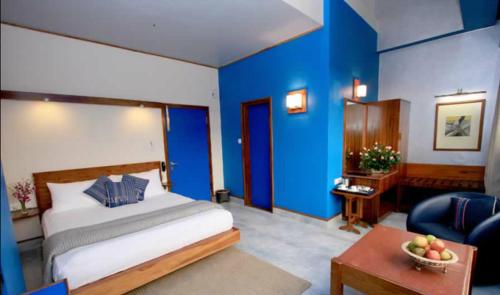a bedroom with a bed and a blue wall at Hotel Centre Point in Shillong