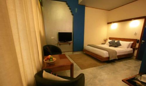 a hotel room with a bed and a chair at Hotel Centre Point in Shillong
