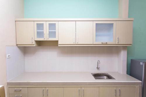 a kitchen with white cabinets and a sink at Batuque Town Villa 2 in Batu