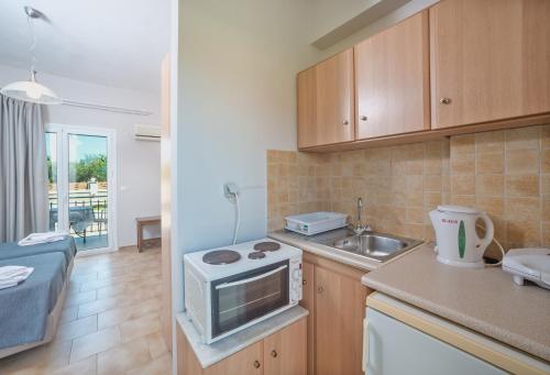 a small kitchen with a sink and a microwave at Villaggio Verde in Laganas