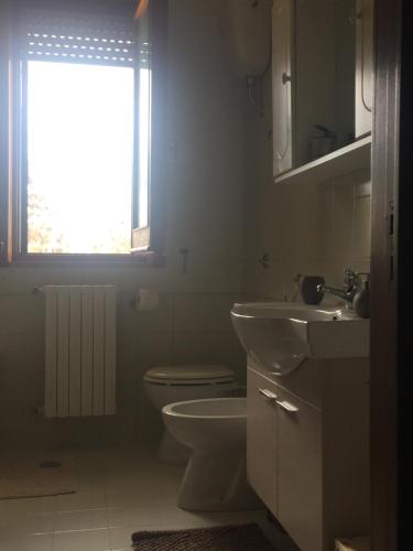 a bathroom with a toilet and a sink and a window at A casa di Gio in Lecce