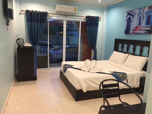 a bedroom with a bed with a chair and a window at PPS Home in Surin
