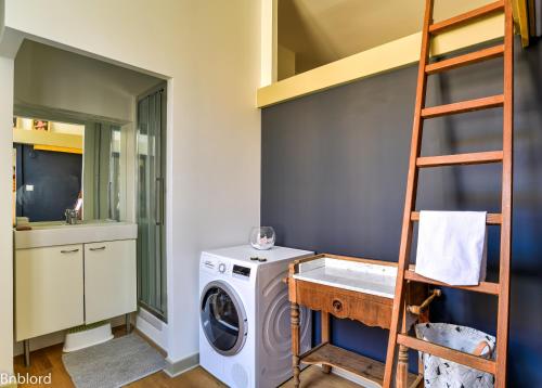 une buanderie avec un lave-linge et une échelle dans l'établissement Bel appartement hypercentre de Strasbourg, à Strasbourg