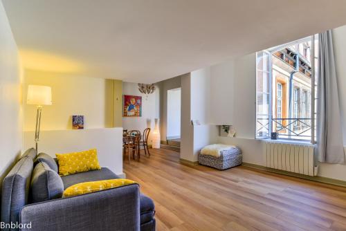 un salon avec un canapé et une grande fenêtre dans l'établissement Bel appartement hypercentre de Strasbourg, à Strasbourg
