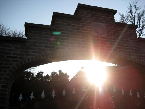 a brick bridge with the sun shining under it at Hotel Plaza in Lommel