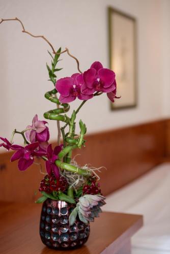 a vase filled with purple flowers on a table at Steichele Hotel & Weinrestaurant in Nuremberg