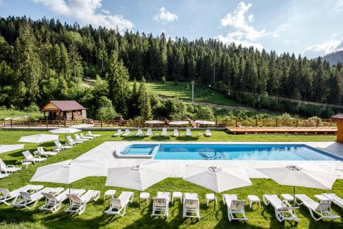 an outdoor pool with chairs and umbrellas at Zahar Berkut in Slavske