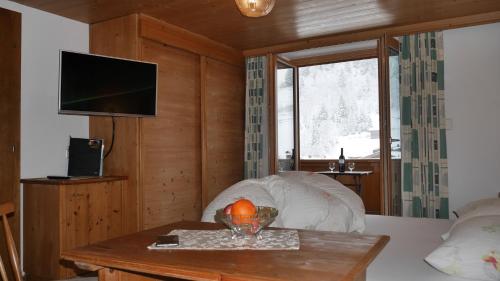 a room with a bed with a table and a television at Pension Bergkristall in Tux