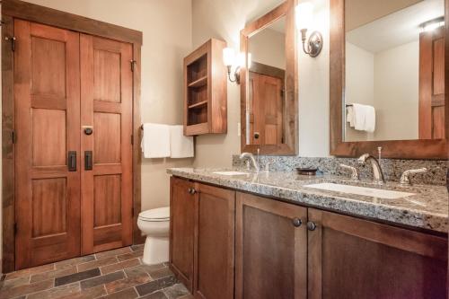a bathroom with a sink and a toilet and a mirror at Woodwinds 25 in Mammoth Lakes