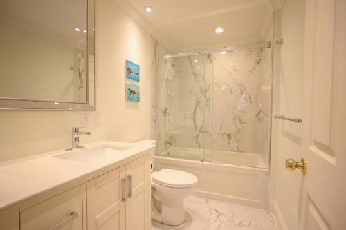a bathroom with a toilet and a shower and a sink at Water Street Condos in St. John's