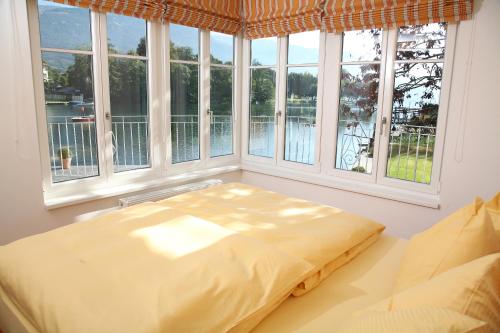 a bed sitting in a room with windows at Villa Cattina in Seeboden