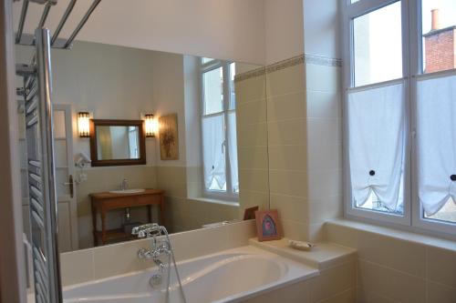 La salle de bains est pourvue d'une baignoire, d'un lavabo et d'un miroir. dans l'établissement Villa Vesone, à Périgueux