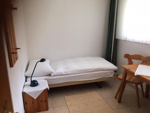 a room with a bed with a lamp on a table at Haus Alpenschloss in Zermatt