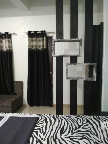 a bedroom with black and white curtains and a zebra print bed at Ashta Lakshmi Tourist Home Stay in Indore
