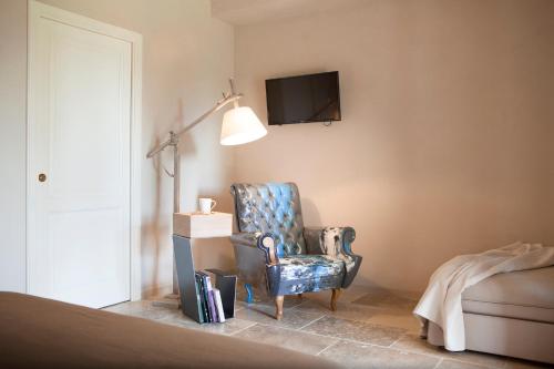a living room with a chair and a lamp at Agriturismo Tra gli Ulivi, Chiappini Winery in Bolgheri
