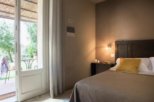 a bedroom with a bed and a large window at Agriturismo Tra gli Ulivi, Chiappini in Bolgheri