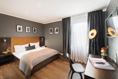 ein Hotelzimmer mit einem Bett, einem Schreibtisch und einem Schreibtisch in der Unterkunft Hotel Düsseldorf Mitte in Düsseldorf