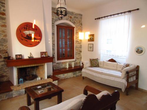 Luxury 100 m2 house in the centre of Naxos في Dhamariónas: غرفة معيشة مع أريكة ومدفأة