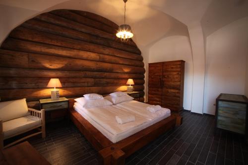 a bedroom with a large bed with a wooden wall at Régi Posta Étterem és Fogadó in Debrecen