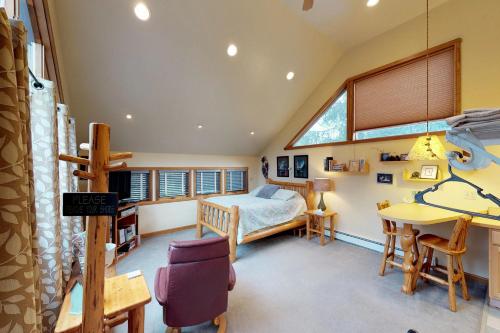 a attic bedroom with a bed and a table and chairs at Crow Creek in Girdwood