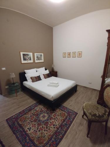 a bedroom with a bed and a chair and a rug at Diadumeno Superior Apartment in Venosa